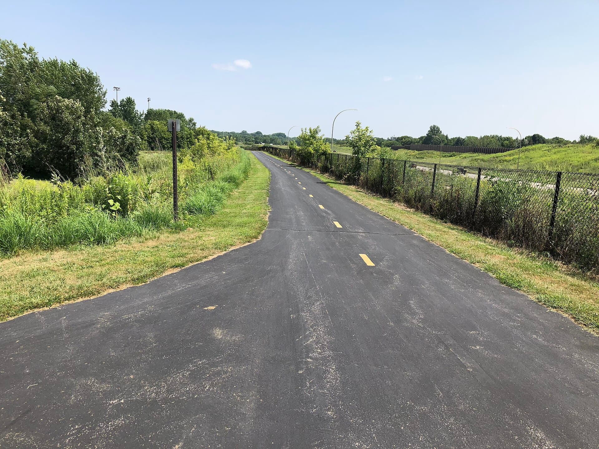 Paved regional trail through green prairie in Eden Prairie, Minnesota